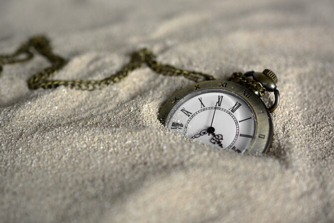watch buried in brown sand showing time - stress releasing mantras